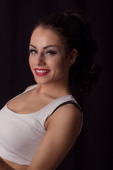 Gorgeous young woman posing against dark studio background