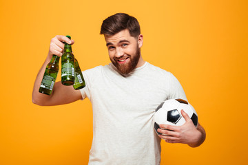 Portrait of a satisfied bearded man holding soccer ball