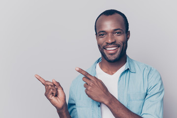 Portrait with empty place of sexy, virile, stunning man with beaming smile pointing two forefingers...