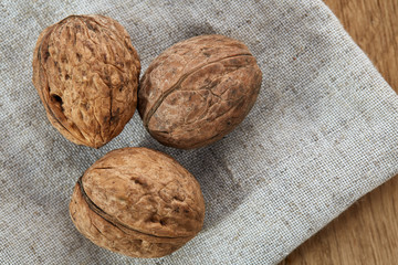 A stack of walnuts piled together and on rustic wooden background, shallow depth of field, selective focus
