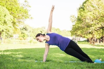 Beautiful woman doing yoga exercises in the park. Concept of healthy lifestyle.