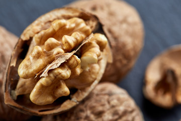 Top view close-up shot of cracked walnuts on dark background, shallow depth of field, macro