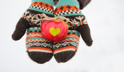 apple with heart in hands in winter