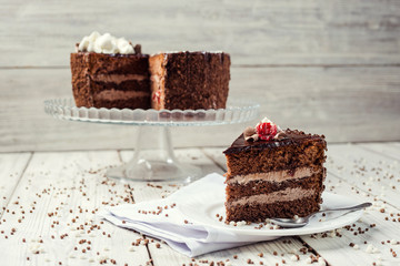 Dark chocolate vegan cake with cherries on wooden background