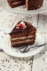 Dark chocolate vegan cake with cherries on wooden background