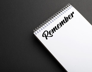 Word remember written on notepad on black background. Concept Copy space. Mockup.