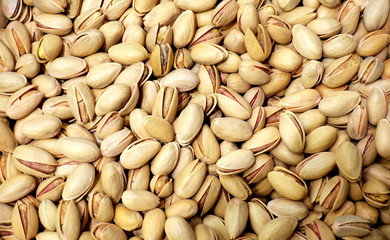 Pile of pistachio nuts in the shell as background.