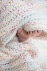 Fototapeta na wymiar baby feet in blanket, copy space. selectiv focus