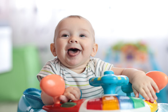 Portrait of funny baby boy at steering wheel toy