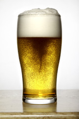 Glass of beer with delicious white foam