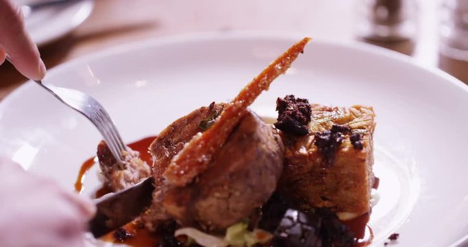 4K Close up on a delicious freshly served gourmet dish with unrecognizable person cutting in & eating