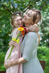 Tochter gratuliert Mutter zum Muttertag mit Blumen