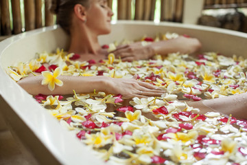 Beautiful woman in the bathroom with flowers
