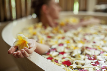 Beautiful woman in the bathroom with flowers
