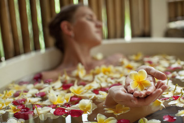 Beautiful woman in the bathroom with flowers
