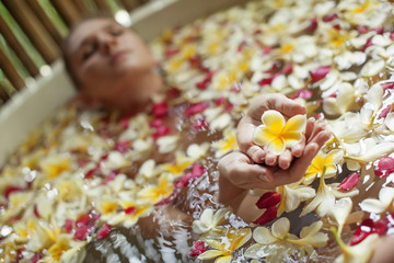 Beautiful woman in the bathroom with flowers
