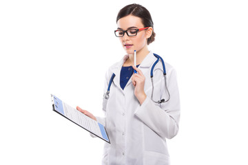 Young woman doctor with stethoscope holding clipboard and pen in her hands in white uniform on white background