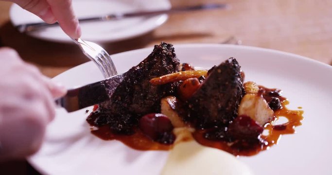 4K Close up on a delicious freshly served gourmet dish with unrecognizable person cutting in & eating