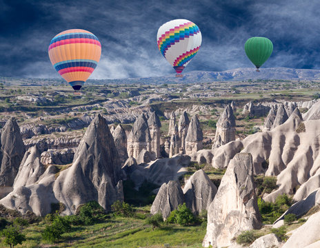 Colorful hot air balloons flying over valleys in Cappadocia, Anatolia, Turkey