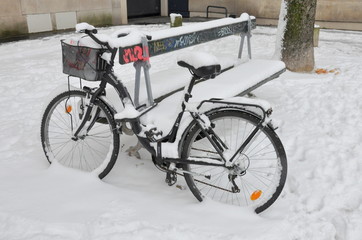 Bicycle stand under snow on a street in Paris