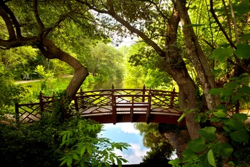Foto auf Acrylglas Eine romantische Kolonialbrücke in Williamsburg, Virginia, eingebettet in ein grünes Waldland mit einem wunderschönen, reflektierenden Wasserteich. © The Nico Studio