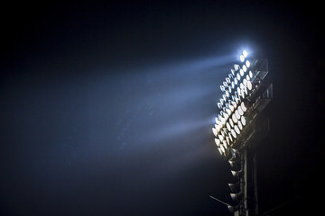Light tower lit at a stadium during nightime. - Powered by Adobe