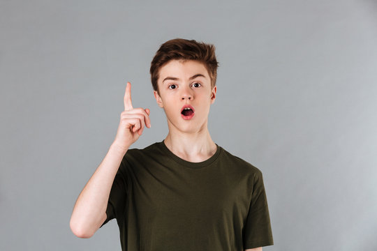 Portrait Of An Excited Male Teenager Wearing T-shirt Pointing