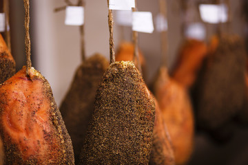Italian ham hung In a factory according to the ancient Italian tradition. Prosciutto is traditional of genuine and healthy food.