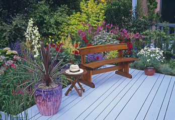 A colourful garden with flower border and decking with seating ready for retirement