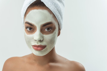 Portrait of serene african girl with mask on face. isolated on grey background. Copy space. Beauty concept