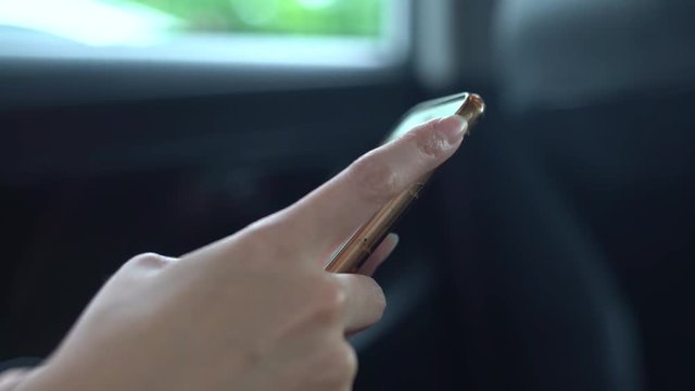 4K Asian woman use mobile phone in a car while travelling. Surfing the internet, checks social network done on her phone device, using smartphone for write text.-Dan