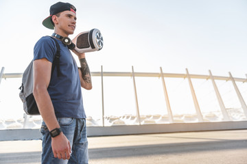 Low angle happy boy keeping gyroscope while walking outdoor. Copy space