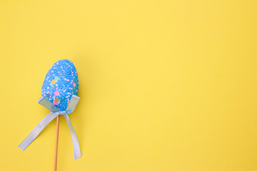 blue easter egg on yellow background