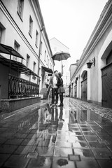happy, loving couple kissing under an umbrella on a city street on a rainy day