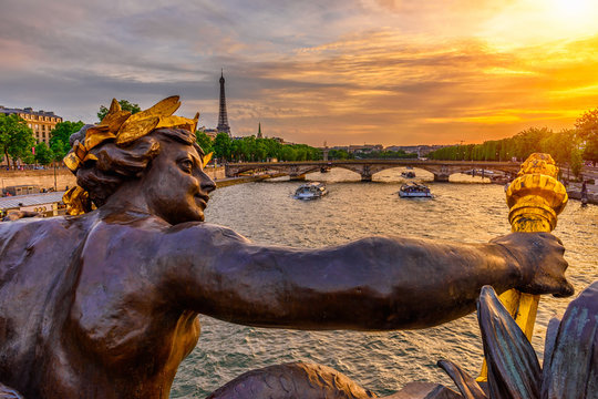 The Nymph reliefs on the bridge of Alexander III with the Eiffel Tower on background at sunset in Paris, France