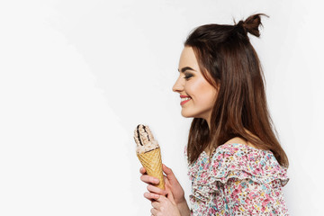 Charming  happy woman poses with an ice-cream in white studio