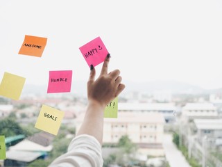 close up woman hands with post it note.