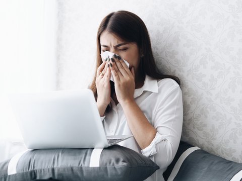 Asian woman  working with laptop in bedroom,she's feeling unwell.