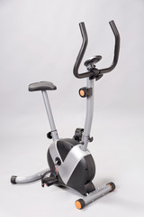 An exercise bicycle against a plain grey background