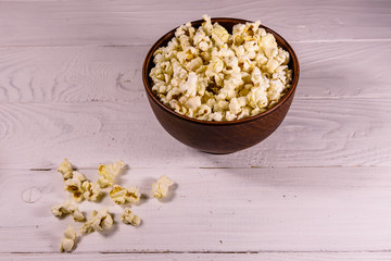Ceramic bowl with popcorn on wooden table