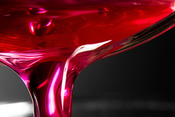 A red and pink beverage is poured into a macro