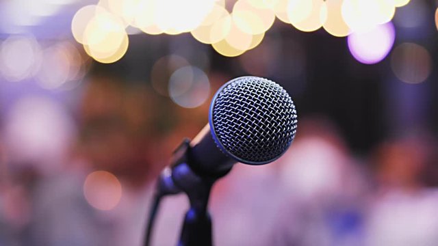 Microphone on the Stand is Standing on the Stage, Close-Up Microphone on the Background of the Auditorium, Spotlight