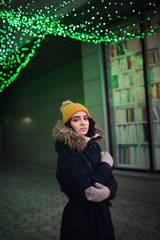 beautiful woman in hat and mittens posing at illumination