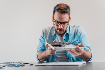 Handsome serious computer engineer repairing hardware