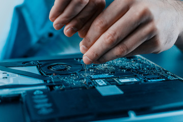Close-up of male hands repairing laptop. Hardware.