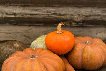 Pumpkins in basket on rustic vintage background on wooden table