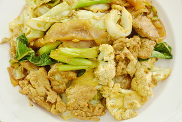 fried large rice noodles with pork and vegetable in black soy sauce on plate