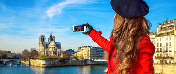 Seen from behind young woman in Paris taking photo