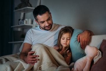 portrait of father looking at innocent sleeping daughter