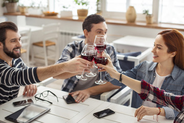 Cheers. Good-looking cheerful old best friends sitting together at the table and drinking wine and talking
